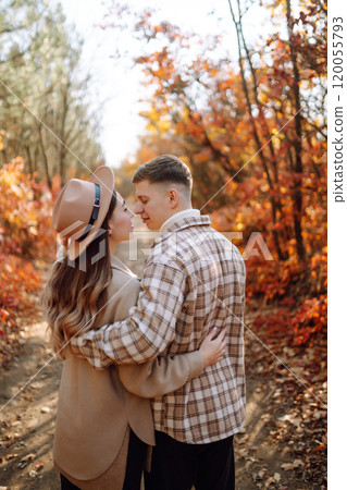 Couple in love newlyweds in casual clothes travel together, hike and walk in autumn forest in nature 120055793