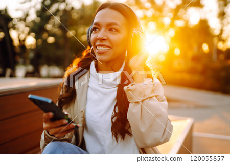 Young woman listens to music, audiobook or podcast. Communication in social networks. Lifestyle. 120055857