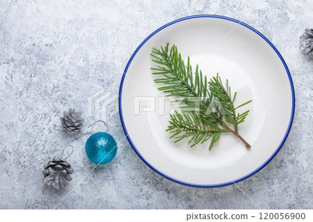 Christmas table setting with fir branch on white plate and decorations 120056900