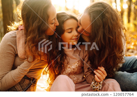 The homosexual family playing with her daughter in the autumn forest. The adventure is more fun. The homosexual family playing with her daughter in the autumn forest. The adventure is more fun. 120057764