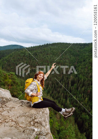 Young woman with backpack on mountain peak looking in beautiful mountain. Nature. 120058161