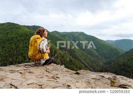Young woman with backpack on mountain peak looking in beautiful mountain. Nature. 120058163