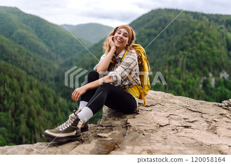 Young woman with backpack on mountain peak looking in beautiful mountain. Nature. 120058164