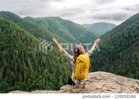 Young woman with backpack on mountain peak looking in beautiful mountain. Nature. 120058166