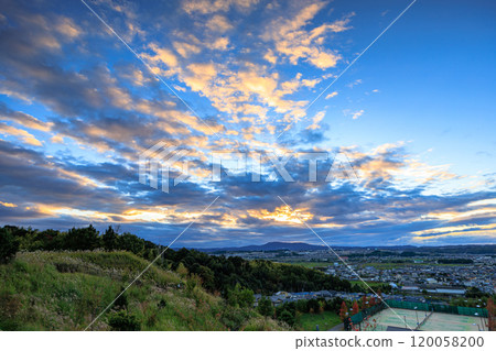 View from the ruins of Shiroyamadai Castle in Kizugawa City, the southernmost part of Kyoto Prefecture. From sunset to night view. Golden sheep clouds shining in the setting sun. 120058200