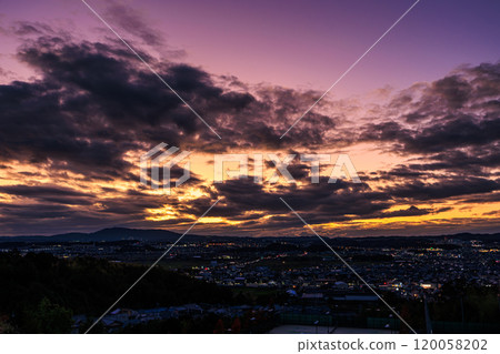 View from the ruins of Shiroyamadai Castle in Kizugawa City, the southernmost part of Kyoto Prefecture. From sunset to night view. The sunset sky changes from golden to reddish purple to dark blue. 120058202