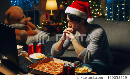 Man drinking tea on his laptop at home on Christmas Man drinking tea on his laptop at home on Christmas 120058219