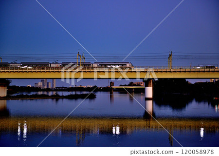 Noborito: Odakyu Line trains shining in the setting sun as seen from upstream the Tama River bank Noborito: Odakyu Line trains shining in the setting sun as seen from upstream the Tama River bank 120058978
