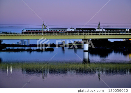 Noborito: Odakyu Line trains shining in the setting sun as seen from upstream the Tama River bank 120059020