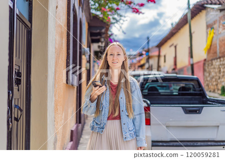 Female tourist walks through the colonial streets San Cristobal de las Casas, Mexico. Cultural exploration, architecture, and travel experience concept Female tourist walks through the colonial streets San Cristobal de las Casas, Mexico. Cultural exploration, architecture, and travel experience concept 120059281