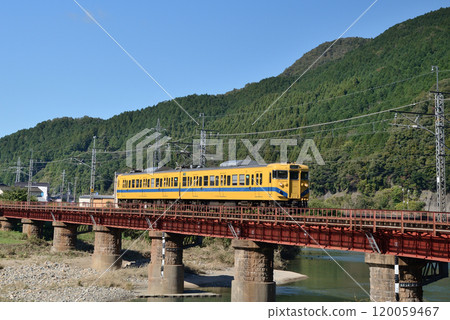 A 113 series Fukuchiyama Line colored local train crossing the Maruyama River Bridge on the Sanin Main Line A 113 series Fukuchiyama Line colored local train crossing the Maruyama River Bridge on the Sanin Main Line 120059467