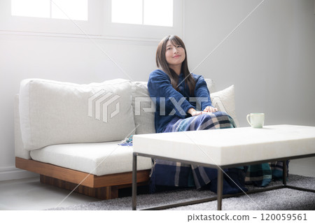 一位穿著可愛冬季睡衣的女子在客廳放鬆，廣角 120059561