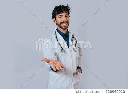 Smiling doctor extending hand in welcome. Young doctor extending hand to camera, Smiling doctor extending hand isolated Smiling doctor extending hand in welcome. Young doctor extending hand to camera, Smiling doctor extending hand isolated 120060020