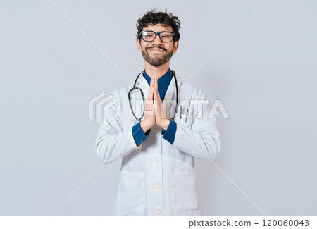 Smiling doctor putting palms together on isolated background. Handsome doctor with hands together isolated. Young doctor with palms together 120060043