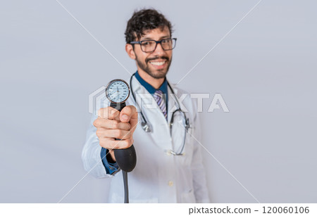 Handsome doctor showing blood pressure monitor isolated. Smiling doctor holding blood pressure monitor Handsome doctor showing blood pressure monitor isolated. Smiling doctor holding blood pressure monitor 120060106
