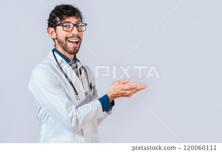 Smiling doctor showing something with his palms. Young doctor presenting something with palms isolated, Handsome doctor showing an advertisement with his palms 120060111