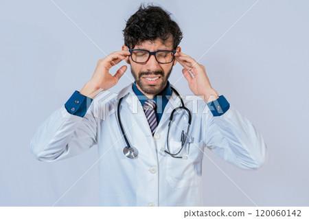 Young Doctor suffering with headache isolated. Doctor with migraine holding his head, Fatigued doctor with headache isolated 120060142