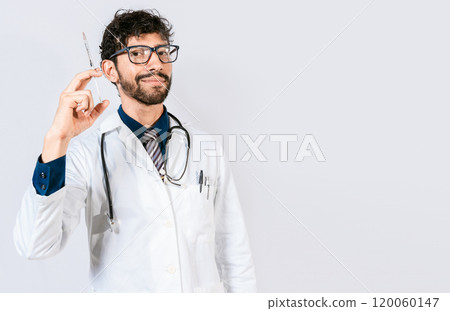 Young doctor holding a syringe isolated. Smiling doctor holding a syringe on isolated background. Doctor and vaccine concept Young doctor holding a syringe isolated. Smiling doctor holding a syringe on isolated background. Doctor and vaccine concept 120060147