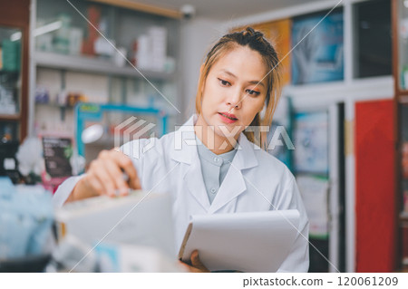 Pharmacist checking Checks Inventory of Medicine, Drugs, Vitamins with tablet and checking patient's prescription in modern pharmacy. 120061209