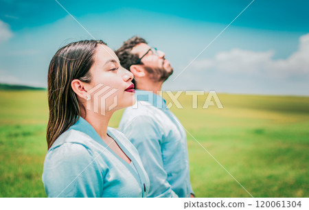 Two relaxed people breathing fresh air in the field. Young couple breathing fresh air in the field 120061304