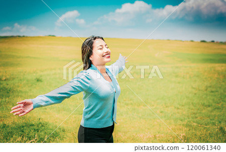 Serene young woman breathing fresh air in beautiful field spreading arms. Happy girl spreading arms breathing fresh air in the field Serene young woman breathing fresh air in beautiful field spreading arms. Happy girl spreading arms breathing fresh air in the field 120061340