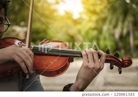 Close up of hands playing the violin outdoors. Violinist artist playing a melody outdoors, Portrait of man playing violin at sunset. Image of a person playing the violin outdoors Close up of hands playing the violin outdoors. Violinist artist playing a melody outdoors, Portrait of man playing violin at sunset. Image of a person playing the violin outdoors 120061383