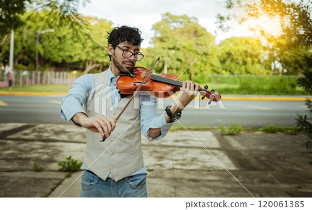 Violinist artist playing a melody outdoors, Portrait of man playing violin outdoor. Close up of violinist man playing in the street. Image of a person playing the violin outdoors Violinist artist playing a melody outdoors, Portrait of man playing violin outdoor. Close up of violinist man playing in the street. Image of a person playing the violin outdoors 120061385