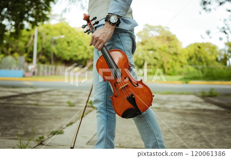 Close up of hands holding violin and hoop. Hands holding violin and hoop outdoors, Concept of person holding violin and hoop outdoors Close up of hands holding violin and hoop. Hands holding violin and hoop outdoors, Concept of person holding violin and hoop outdoors 120061386