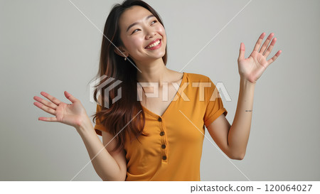 Asian Woman Happily Pointing to Upper Side with Both Fingers in Studio Asian Woman Happily Pointing to Upper Side with Both Fingers in Studio 120064027