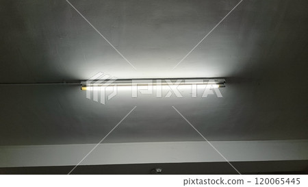 Fluorescent Light Illuminating a Minimalist Industrial Ceiling 120065445