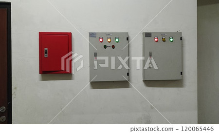 Fire Safety and Electrical Control Panels on White Wall 120065446