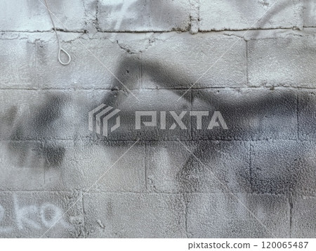 A grey and white wall with a few spots of color 120065487