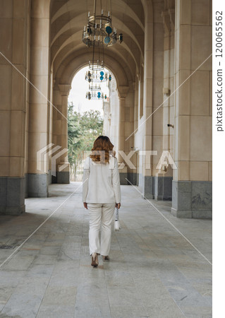 Woman White Suit Walking Arched Corridor Building Entrance Woman White Suit Walking Arched Corridor Building Entrance 120065562
