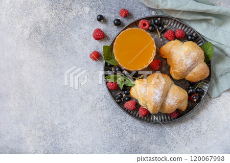 Tasty freshly baked croissants and orange juice on a grey stone  background, breakfast concept. 120067998