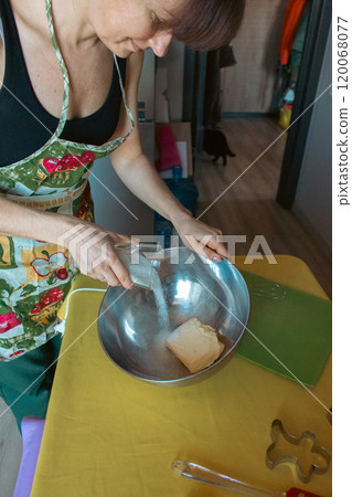 Woman in apron making ginger dough in domestic kitchen. Preparing homemade cookies. Woman hands mixing ingredients for Christmas cookies. Kneading dough proccess. Domeatic lifestyles. Real life moment Woman in apron making ginger dough in domestic kitchen. Preparing homemade cookies. Woman hands mixing ingredients for Christmas cookies. Kneading dough proccess. Domeatic lifestyles. Real life moment 120068077