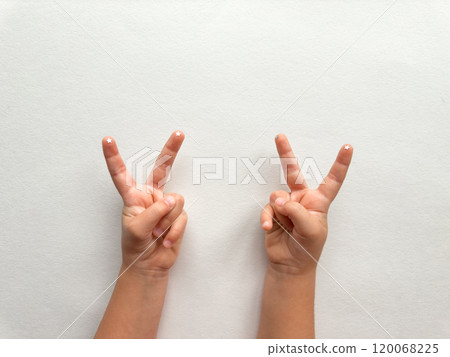 Childs hands showing peace sign on minimalist white background Childs hands showing peace sign on minimalist white background 120068225