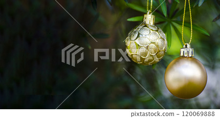 Golden Christmas ball with customizable space for Christmas wishes with blurred Christmas trees background. Christmas celebration concept 120069888