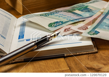On the open diary page there are several monetary denominations and a fountain pen 120070120