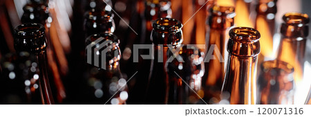 Header image of dozen open glass bottles shining in light while standing in lines at craft beer factory, copy space 120071316