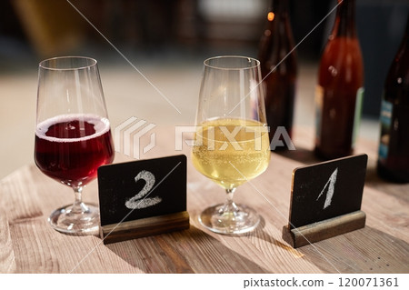 Background shot of two craft cider samples featuring apple and fruit flavors served in glasses for degustation in factory cellar, copy space 120071361