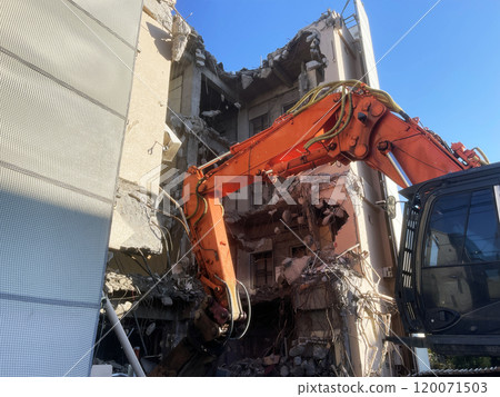 An excavator destroys a residential building An excavator destroys a residential building 120071503