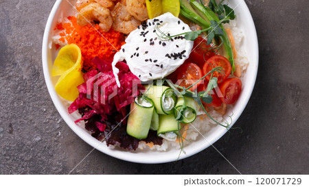 Scrumptious seafood rice bowl with fresh vegetables and egg on a dark background 120071729