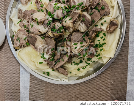 The Kazakh national dish is beshbarmak. thinly sliced beef and lamb on a large round plate with dough. 120071731