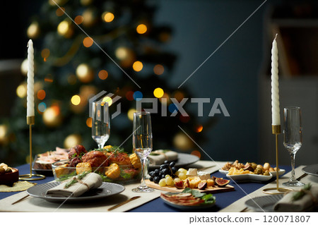 Background shot of turkey dinner with cheese and fruit platters served with side dishes at festive table decorated with candlesticks, copy space Background shot of turkey dinner with cheese and fruit platters served with side dishes at festive table decorated with candlesticks, copy space 120071807