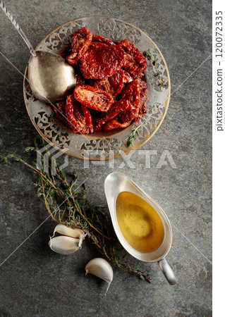 Homemade sun-dried tomatoes in olive oil with thyme and garlic. Homemade sun-dried tomatoes in olive oil with thyme and garlic. 120072335