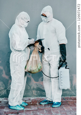 The virus fighting unit. Shot of two healthcare workers wearing hazmat suits working together during an outbreak in the city. 120072472