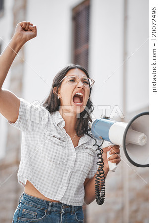 Go out and grab the world. Shot of a young woman screaming into a loud speaker while protesting in the city. Go out and grab the world. Shot of a young woman screaming into a loud speaker while protesting in the city. 120072496