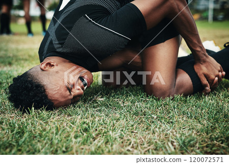 What a bad mishap. Cropped shot of a handsome young rugby player suffering with an injury on the field. 120072571
