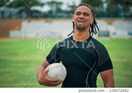 Rugby is my thing. Cropped portrait of a handsome young rugby player smiling while holding a rugby ball on the field. 120072682