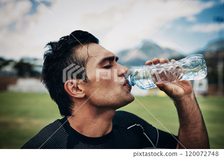 You gotta stay hydrated on the field. Cropped shot of a handsome young rugby player drinking water while standing on the field during the day. You gotta stay hydrated on the field. Cropped shot of a handsome young rugby player drinking water while standing on the field during the day. 120072748